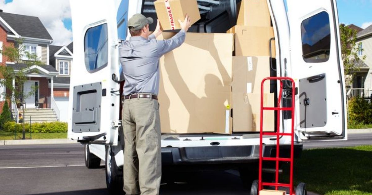 A man loading a box into the van